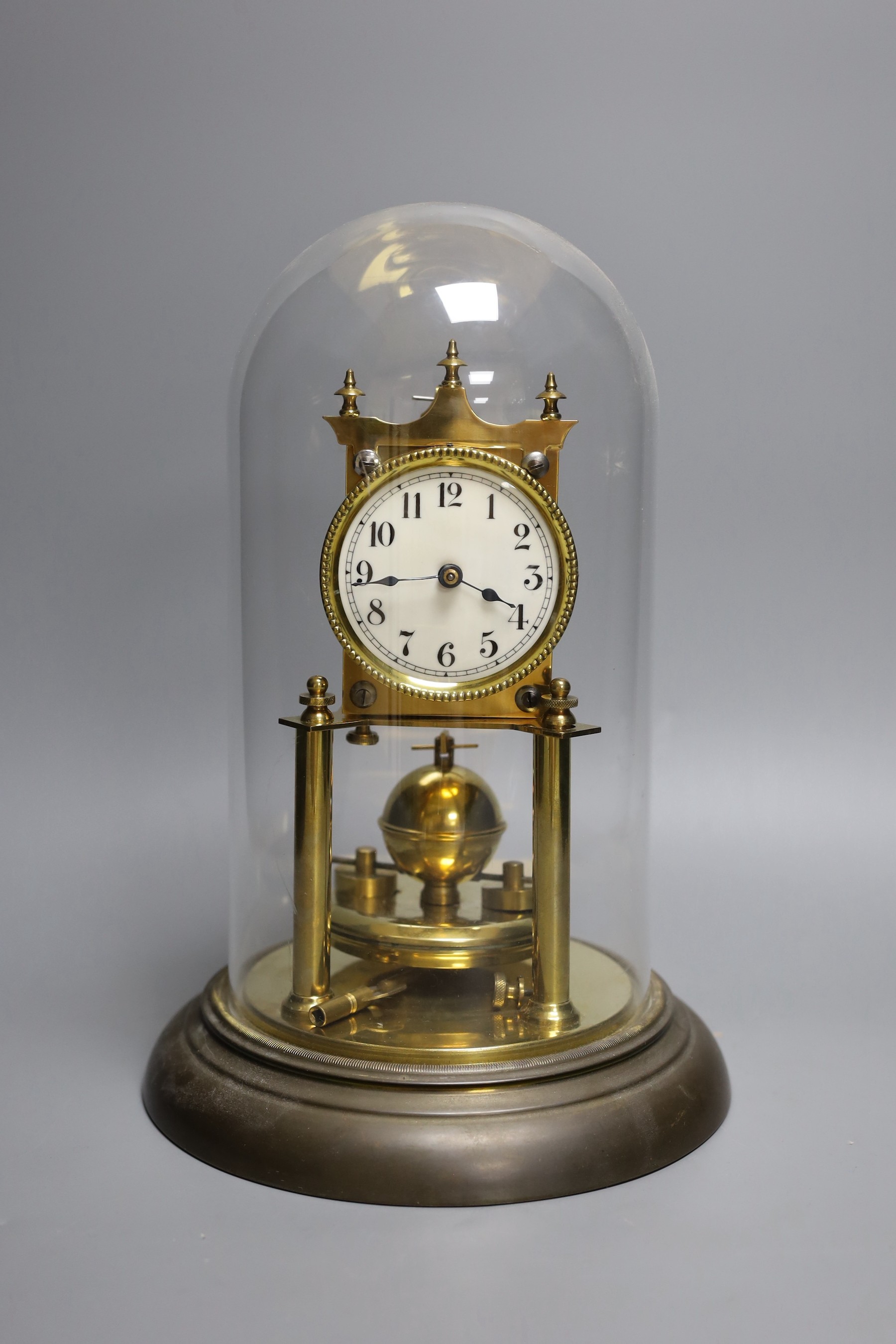 A German 400 day brass mantel timepiece, under a glass dome 29cm total height